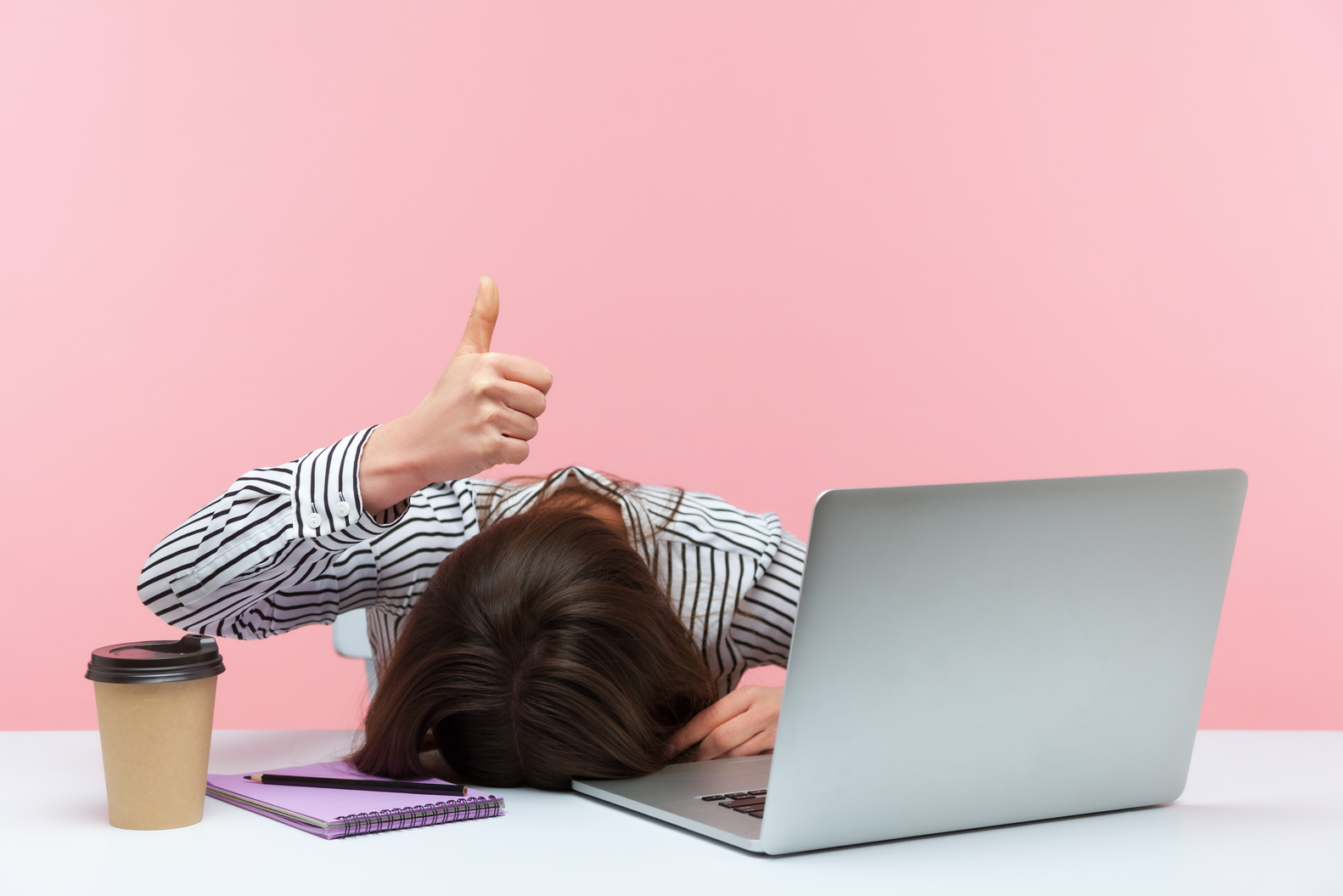 Emotional Young Woman Sitting and Working on Office with Pink Background.